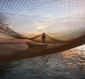 Fishing net over river during sunset
