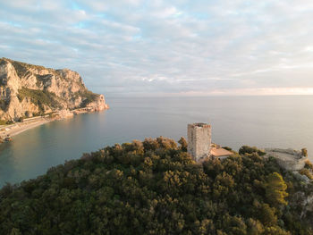 Scenic view of sea by buildings against sky