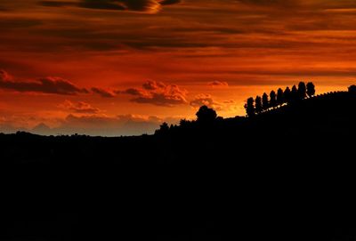 Silhouette landscape against orange sky