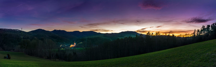 Panoramic view of green landscape and mountains at sunset
