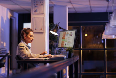 Side view of businesswoman working at office