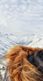 Close-up of fur jacket against mountains and sky