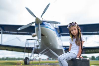 Portrait of young woman sitting against sky