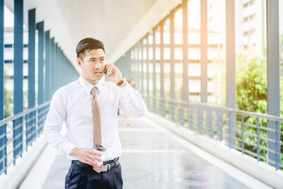 Young man standing against railing