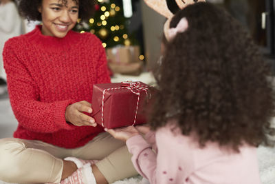 Portrait of a smiling young woman holding christmas tree