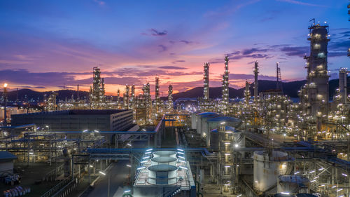 Aerial view oil and gas tank with oil refinery background at night, glitter lighting petrochemical.