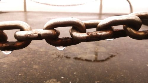 Close-up of rusty chain on railing