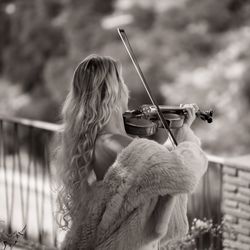 Side view of woman playing violin