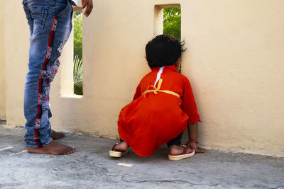 Rear view of couple kissing against wall