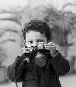 Portrait of young boy photographing through camera