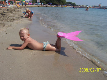 Rear view of woman sitting on beach