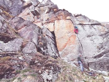 Low angle view of rocks on rock against mountain