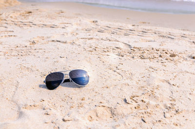 Close-up of sunglasses on beach