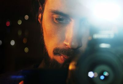 Close-up of young man photographing through camera