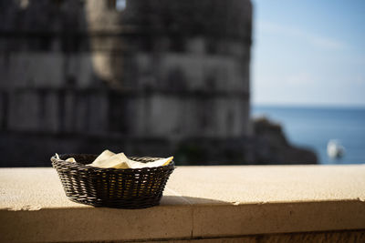 Close-up of ice cream cone on retaining wall against sea