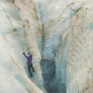 High angle view of man climbing glacier