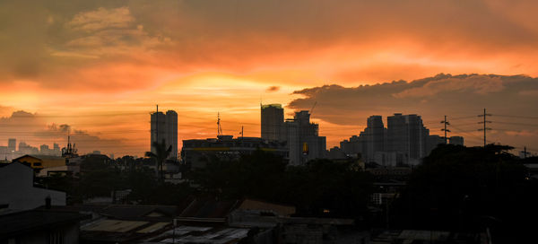 Silhouette buildings against sky during sunset