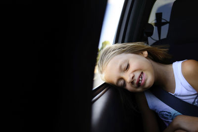 Girl napping while sitting in car