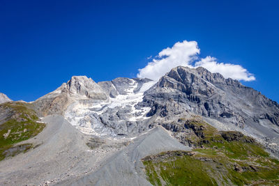 Scenic view of snowcapped mountains against blue sky