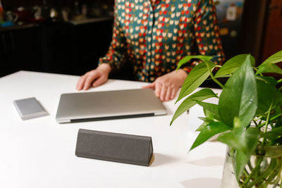 Midsection of woman using smart phone on table