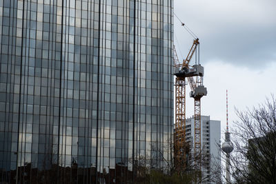 Construction site by buildings against sky in city