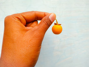 Close-up of hand holding orange