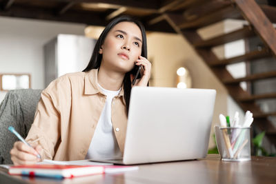 Young woman using laptop at table