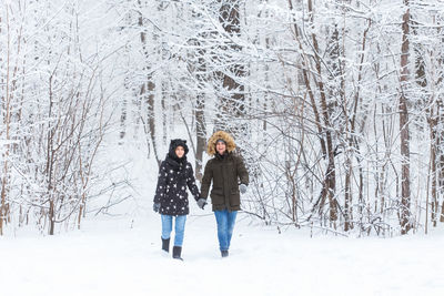 Full length of two people on snow covered landscape
