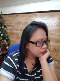 Portrait of a young woman wearing eyeglasses at home