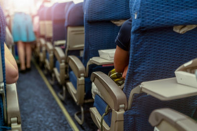 Passenger inside economy seat of commercial airplane. plane cabin interior. blur stewardess.