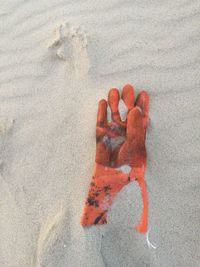 High angle view of a glove on sand at beach