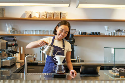 Portrait of young woman standing in store