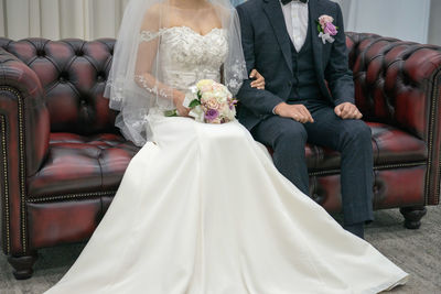 Bride and groom sitting on sofa