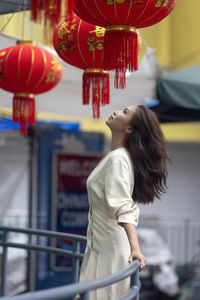 Side view of young woman holding umbrella