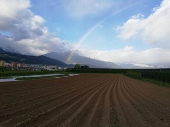 Panoramic view of agricultural field against sky