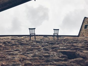 Lifeguard chair on beach against sky