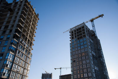 Tower crane working at construction site on blue sky background with white clouds. construction 