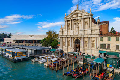 Boats in canal amidst buildings in city