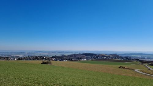 Scenic view of field against clear blue sky