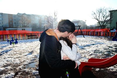 Young couple in playground in winter