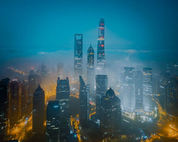 Illuminated buildings in city against sky