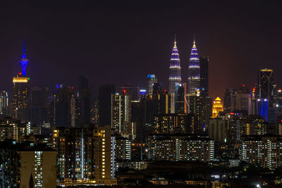 Illuminated cityscape against sky at night