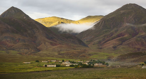 Scenic view of mountain range against cloudy sky