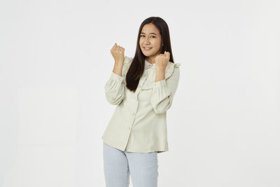 Portrait of smiling young woman against white background