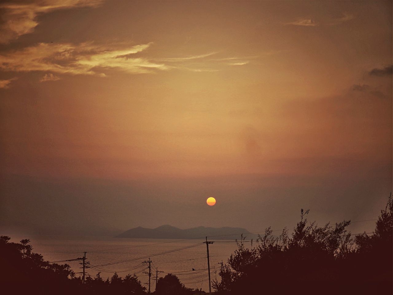 sunset, silhouette, orange color, scenics, sky, beauty in nature, tranquility, tranquil scene, nature, idyllic, sun, tree, dusk, cloud - sky, outdoors, dramatic sky, low angle view, no people, moody sky, dark