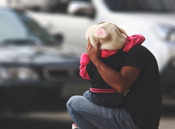 Side view of father embracing child on road