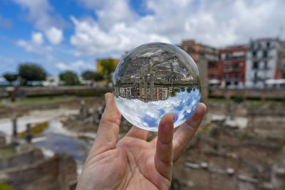 Midsection of person holding crystal ball glass
