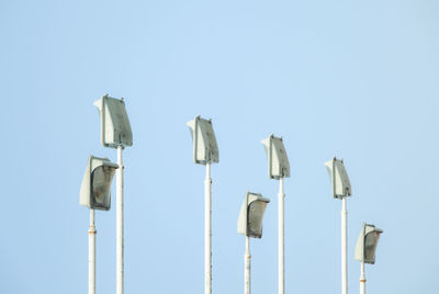 Low angle view of poles against clear sky