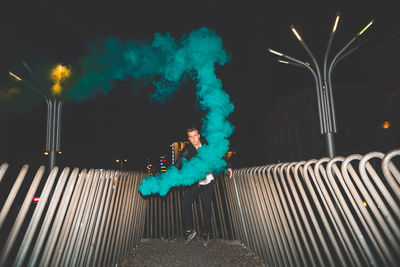 Man with illuminated lighting equipment at night