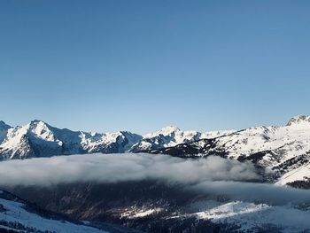 Scenic view of snowcapped mountains against clear blue sky